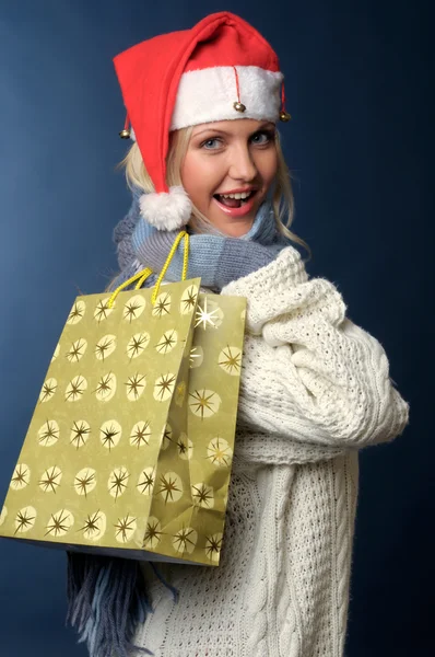Hediye çanta ile Noel Baba şapkalı sarışın kız — Stok fotoğraf