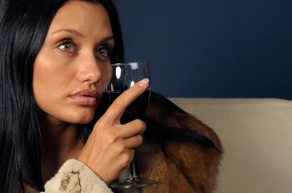 Žena v kožešinách nezdolnou víno. — Stock fotografie