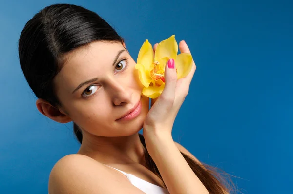 Beautiful girl with yellow orchid — Stock Photo, Image