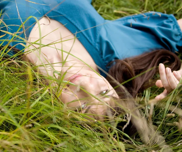 Ung vacker flicka ligger på en gräs — Stockfoto