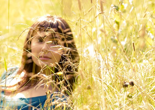 Mooi meisje in een gras — Stockfoto