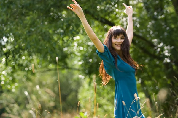 Счастливая девушка прыгает на зеленой поляне — стоковое фото