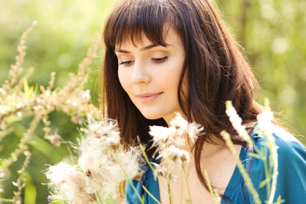 Ung vacker flicka bland fluffiga växter — Stockfoto