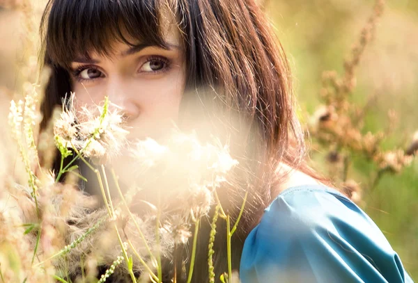 Ung vacker flicka bland fluffiga växter — Stockfoto