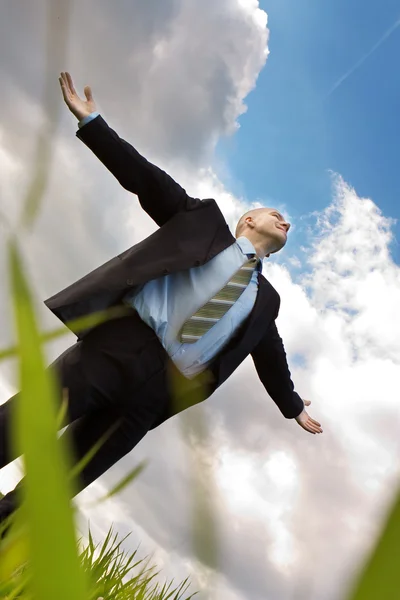 Happy businessman embraces the sky — Stock Photo, Image