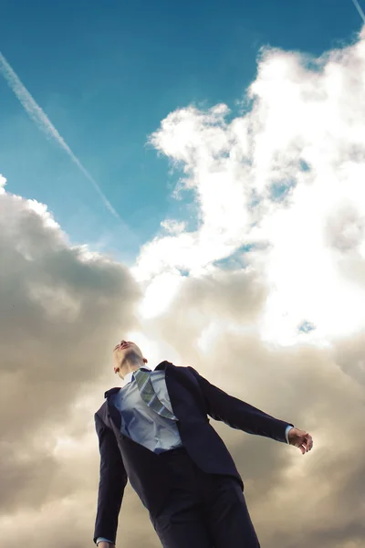 Νεαρός άνδρας σε ένα κοστούμι ενάντια στον ουρανό — Φωτογραφία Αρχείου