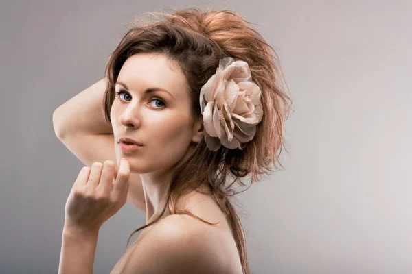 Joven hermosa chica con una rosa en el pelo —  Fotos de Stock