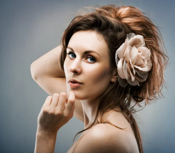 Giovane bella ragazza con una rosa nei capelli — Foto Stock