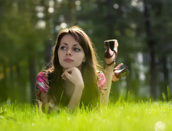 Mooi meisje op een gras — Stockfoto
