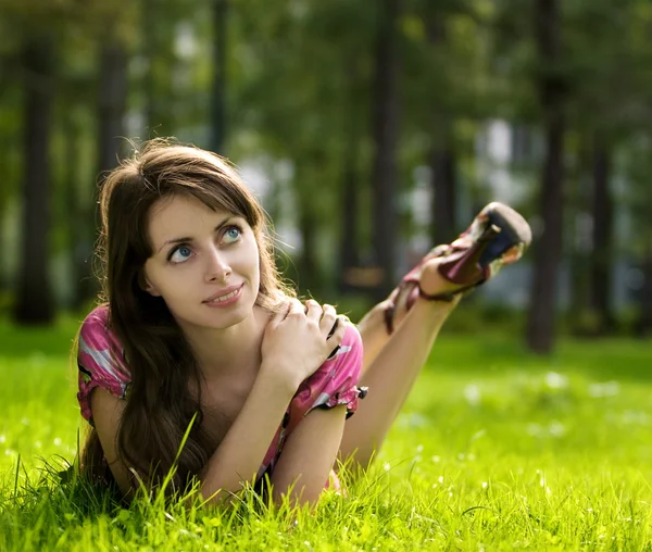 Mooi meisje op een gras — Stockfoto