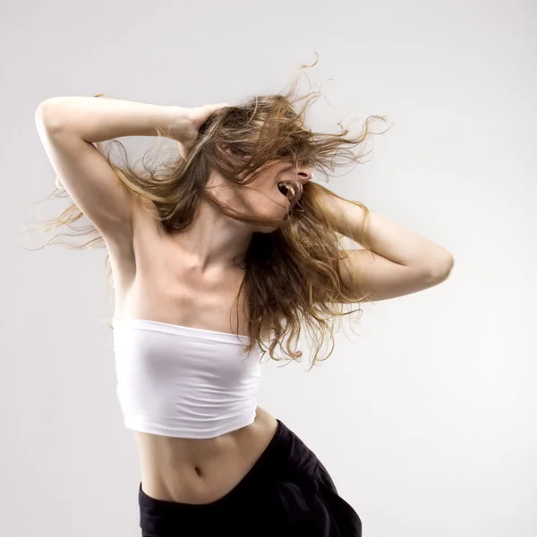 Танцующая молодая девушка машет волосами — стоковое фото