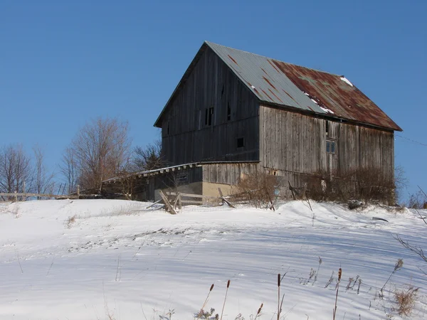 雪の丘の上の納屋 — ストック写真