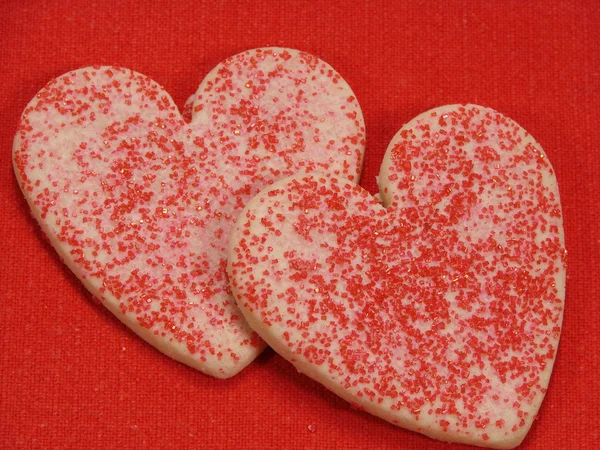Hjärtat socker cookies på röd Royaltyfria Stockfoton