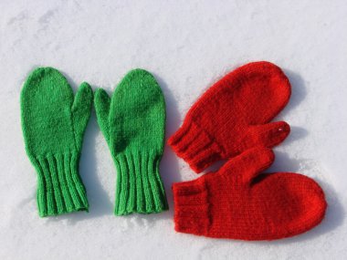 Two pairs mittens in the snow clipart