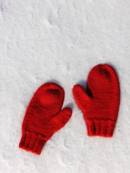 Пара красных варежки в снегу — стоковое фото