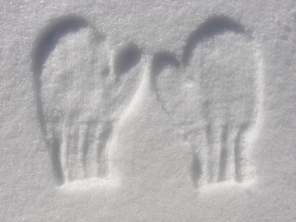 Intryck av par vantar i snö Stockbild