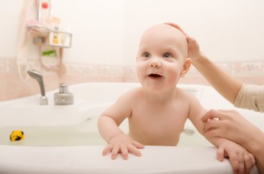 Mother washing child's head clipart