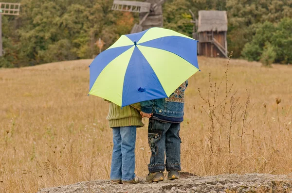 Malý chlapec a dívka s deštníkem — Stock fotografie