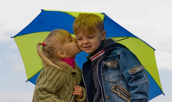 Malý chlapec a dívka s deštníkem — Stock fotografie