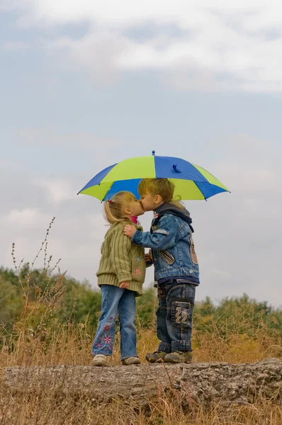 Kleine jongen en meisje met paraplu — Stockfoto