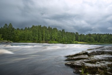 Storm clouds over river and forest clipart