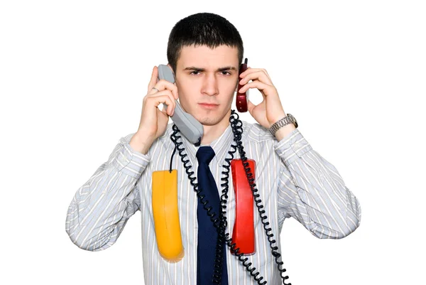 O jovem fala por dois telefones — Fotografia de Stock