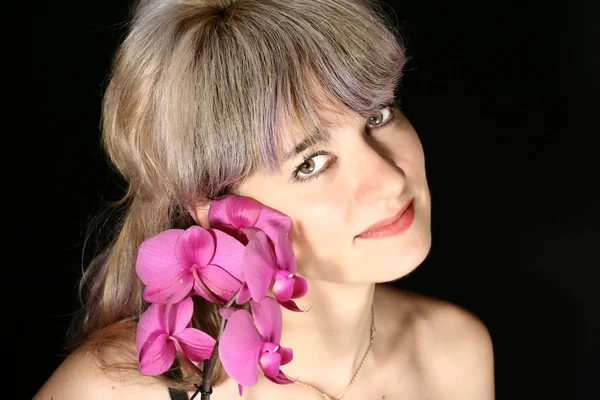 Bella donna e orchidea vicino al viso — Foto Stock