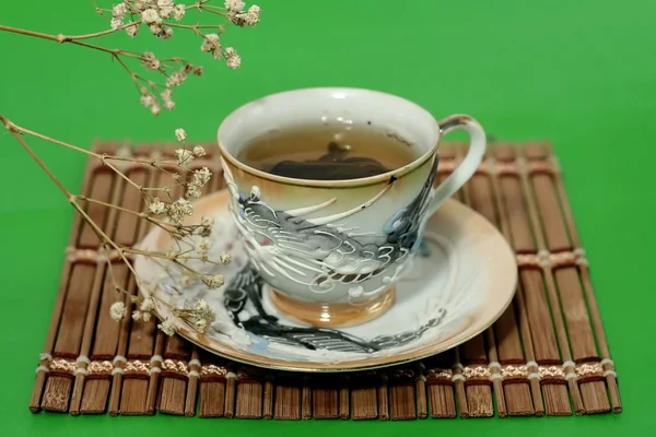 Une tasse de thé vert et une goutte d'eau — Photo