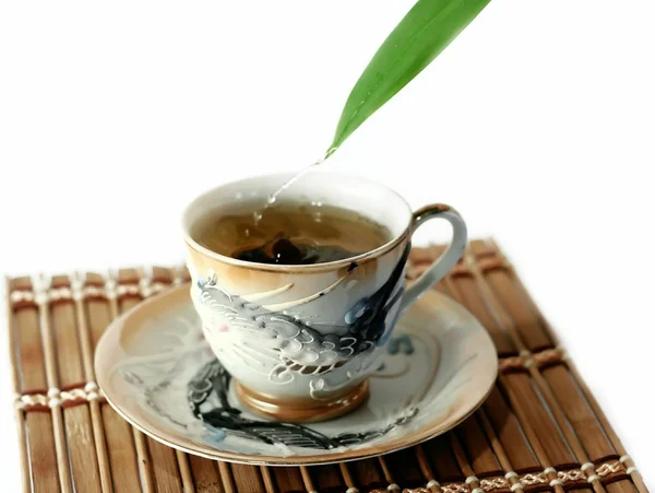 A cup of tea and drops isolated on white — Stock Photo, Image