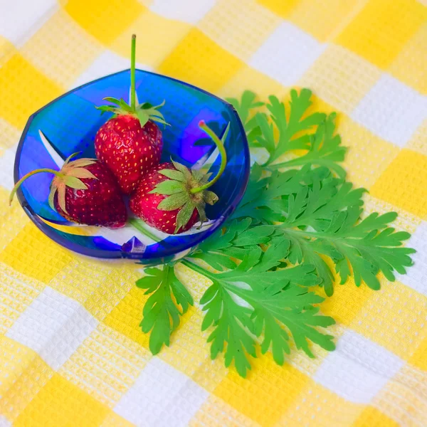 Tre jordgubbar liggande på tallrik med rutig — Stockfoto