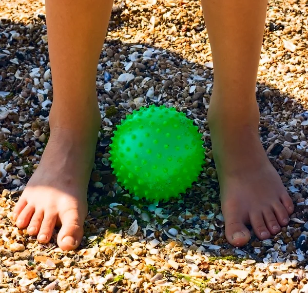 緑色のボールに砂の上の子供の足 — ストック写真