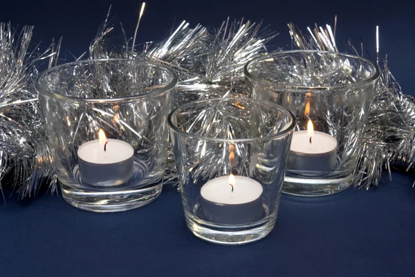 Silbernes Lametta und drei Kerzen — Stockfoto