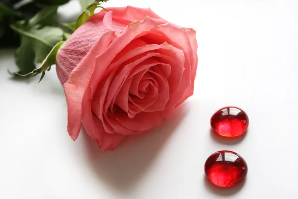 Růžová růže a dva skleněné dekorace — Stock fotografie