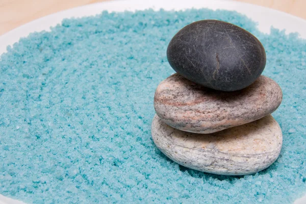 Steine und blaues Badesalz auf dem Teller — Stockfoto