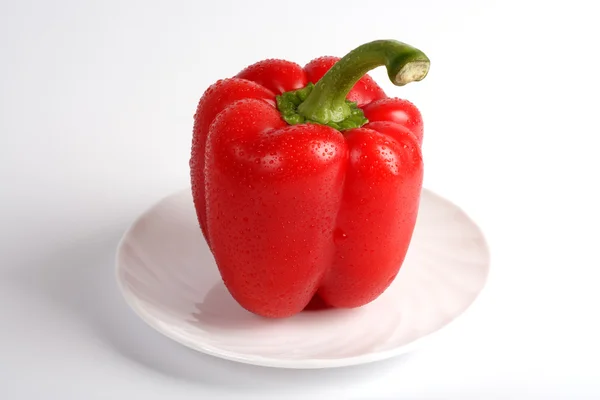 Red sweet pepper on a white plate. Stock Picture