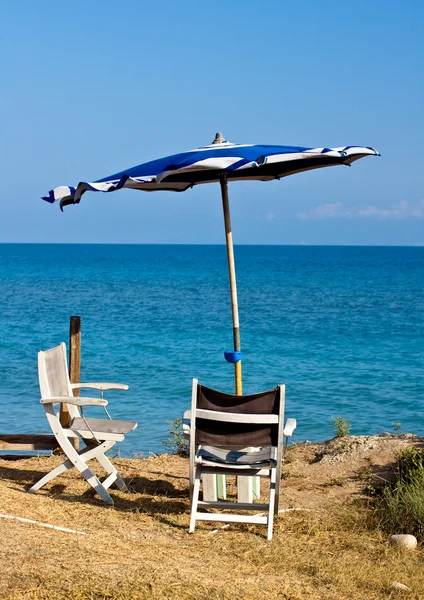 Пляжный зонтик и стул — стоковое фото