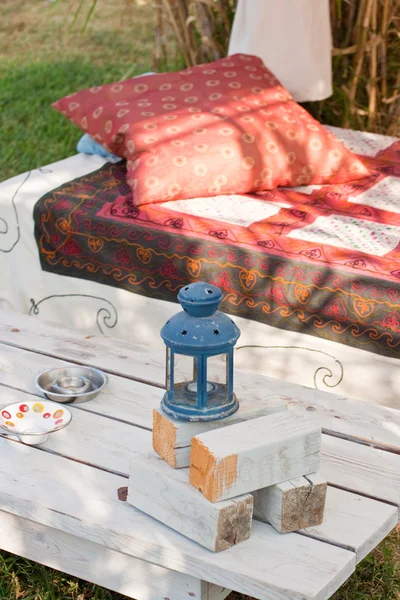 Κρεβάτι και τραπέζι σε ένα κήπο — Φωτογραφία Αρχείου