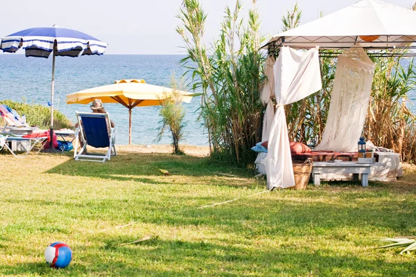 Беседка с пляжным зонтиком и стулом — стоковое фото