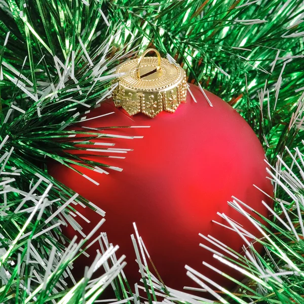Red christmas ball in green — Stock Photo, Image