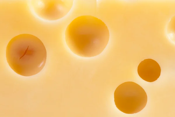 Stuk van smakelijke kaas als achtergrond — Stockfoto