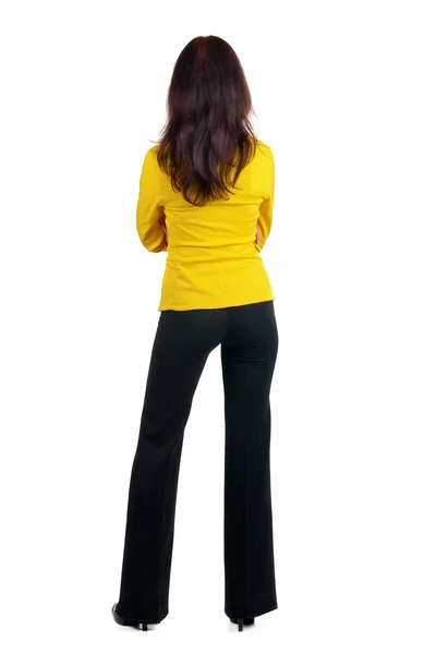 Vrouw in gele pak muur kijken. — Stockfoto