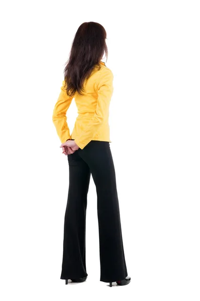 Frau im gelben Anzug, Blick auf Mauer. — Stockfoto