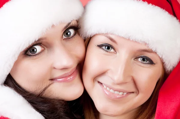Twee meisje vrienden in kerst kostuums op wit — Stockfoto