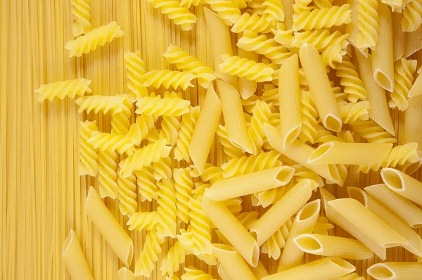 Achtergrond macaroni op lange spaghetti. — Stockfoto