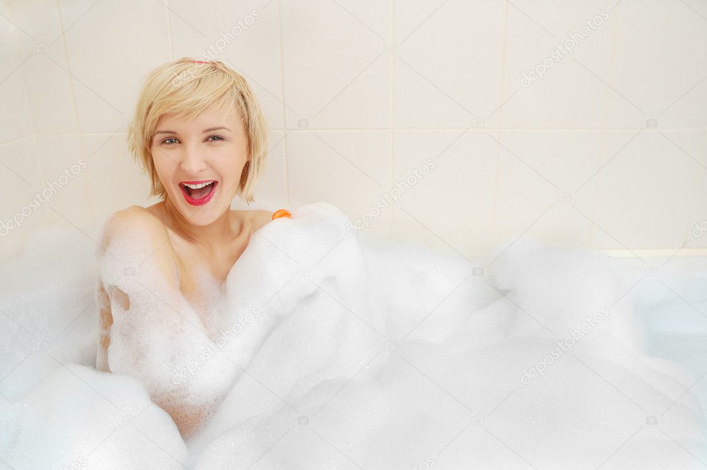 Woman lying in bubble bath .