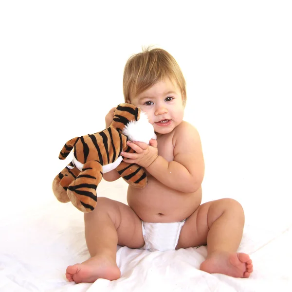 Cute toddler hugging tiger toy — Stock Photo, Image