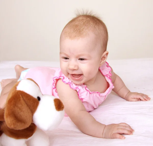 Adorable baby playing with puppy toy — Stock Photo, Image