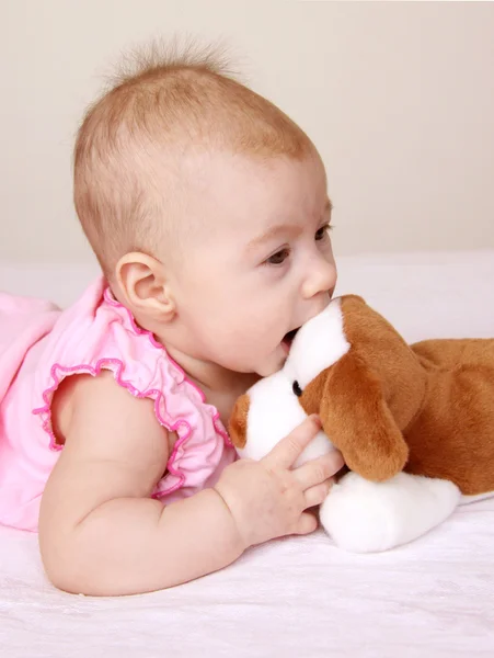 Adorable baby playing with puppy toy — Stock Photo, Image