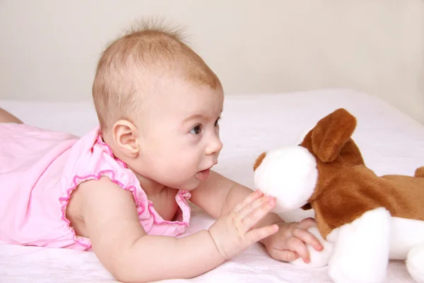 Schattige baby spelen met puppy speelgoed — Stockfoto
