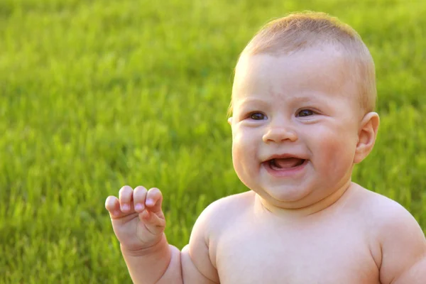 Счастливый ребенок на зеленой траве — стоковое фото